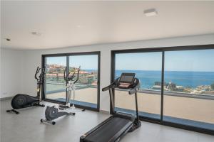 een fitnessruimte met 2 hometrainers en uitzicht op de oceaan bij OurMadeira - Bayside Apartment in Câmara de Lobos