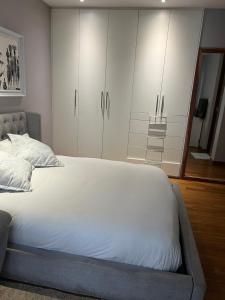 ein Schlafzimmer mit einem großen Bett und weißen Schränken in der Unterkunft Private Room in Waterfall in Northdene