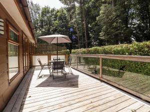 una mesa y sillas en una terraza con sombrilla en Washburn Lodge, en Harrogate