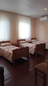a hotel room with three beds and a window at Guest House Giorgi in Ureki
