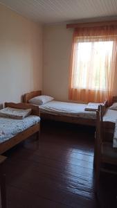 a room with three beds and a window at Guest House Giorgi in Ureki