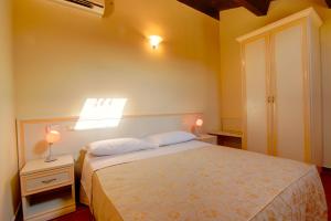 ein Schlafzimmer mit einem Bett und zwei Leuchten an einer Wand in der Unterkunft Butterfly's House in Porto Recanati