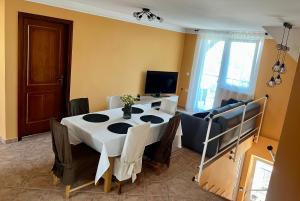 a dining room with a table with chairs and a television at Pacek Keco in Alsóörs