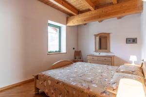 1 dormitorio con 1 cama con tocador y ventana en Casa Giulia, Baselga di Pinè Ospitar, en Montagnaga