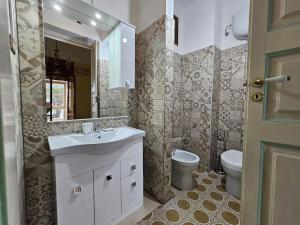 y baño con lavabo, aseo y espejo. en Casa Vacanze Salento MAre, en Galatone