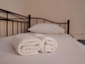 a pile of white towels on a bed at Vironas Hotel in Himare