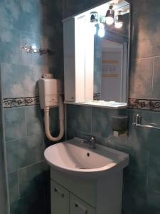 a bathroom with a sink and a mirror at Hotel Mya in Bistriţa