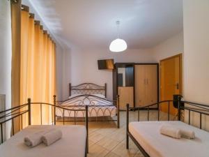 a room with two beds and a bedroom with a bed at Vironas Hotel in Himare