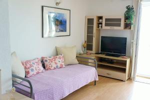 a living room with a couch and a tv at Apartments Permida in Dramalj