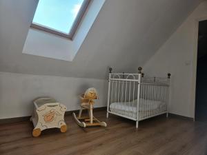 a childs room with a crib and a window at Gite Le haut du Caraquet in Desvres