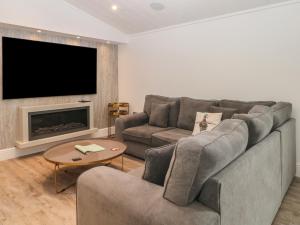 a living room with a couch and a tv at Ruperts Retreat in Preston