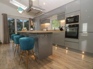 a kitchen with a bar with blue bar stools at Ruperts Retreat in Preston
