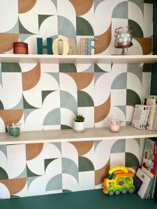 a book shelf with a patterned wall at Confort & style dans ce joli appartement de 44 m2, chambre séparée, PLEIN CENTRE de Dole in Dole +9 photos