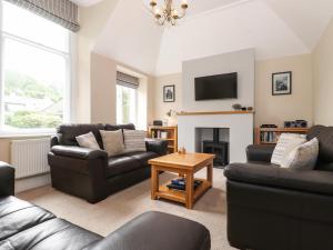 a living room with two couches and a fireplace at Wansfell Loft in Ambleside
