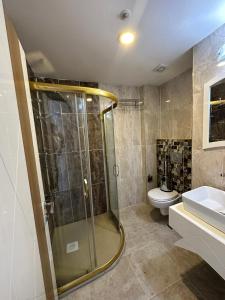 a bathroom with a shower and a toilet and a sink at GrandPazarcıkOtel 