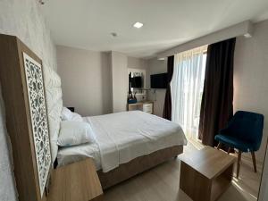 Habitación de hotel con cama y silla azul en GrandPazarcıkOtel, 