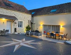 a patio with a table and chairs next to a building at Suzy home in Moisenay