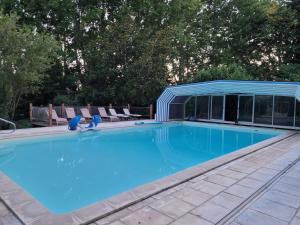 a large swimming pool with a blue roof at Eden - Mas de Rousseau in Eyragues +18 photos