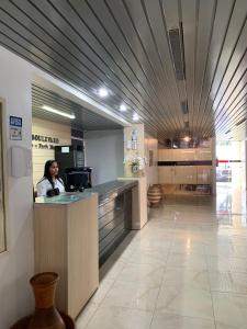 a woman sitting at a counter in a hospital lobby at Boulevard Park Hotel in São Luís
