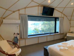 um quarto com uma grande janela numa tenda em GLAMPING DO MAR em Baiona