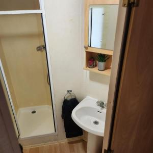 a small bathroom with a sink and a shower at Mobilný domček na brehu Liptovskej Mary in Hliník