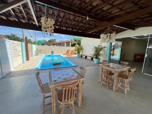 a patio with a pool and chairs and a table at Pousada Donna Maraka in Porto De Galinhas
