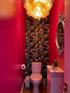 a pink bathroom with a toilet and a sink at Grammar School Yard in Hull