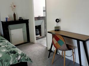 a room with a table and a chair and a fireplace at Chambres d'hôtes du Couesnon in Saint-Ouen-des-Alleux +7 photos