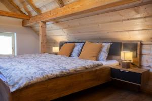 um quarto com uma cama grande num chalé de madeira em Marjeta em Begunje na Gorenjskem