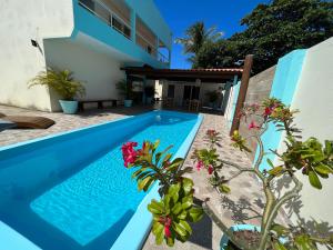 a swimming pool in the backyard of a house at Pousada Donna Maraka in Porto De Galinhas