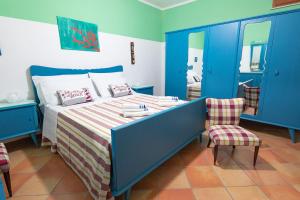 um quarto com uma cama com armários azuis e uma cadeira em Villetta a 30 mt dal mare em Trabia