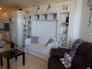 salon z białą kanapą i stołem w obiekcie Estudio Deluxe El Faro w mieście Torrox Costa +5 zdjęć