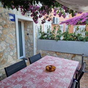 a table with a plate on it on a patio at Apartment Fay in Mali Lošinj