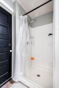 a bathroom with a shower with a white shower curtain at Suite near downtown Louisville, KY - Suite IX in Louisville