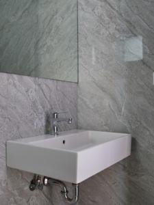 a white sink in a bathroom with a mirror at Vironas Hotel in Himare
