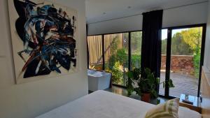 um quarto com uma cama e um quadro na parede em Casa Cuartel Centenillo - Alojamientos Rurales en Sierra Morena em El Centenillo