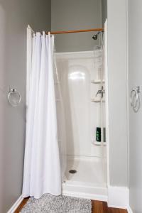 a shower with a white shower curtain in a bathroom at Suite near downtown Louisville, KY - Suite II in Louisville