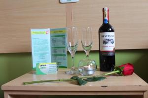 a bottle of wine and two wine glasses on a table at Hostal Terra 3 - BASE AÉREA in Quito