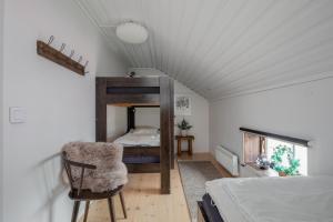 a bedroom with a bunk bed and a chair at Brudtallen in Fryksås