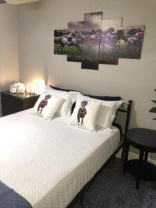 a bedroom with a white bed with paintings on the wall at Suite near downtown Louisville, KY - Suite XI in Louisville