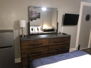 a bedroom with a dresser with a mirror on it at Suite near downtown Louisville, KY - Suite XI in Louisville