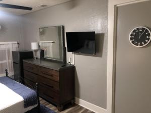 a bedroom with a dresser and a mirror and a clock at Suite near downtown Louisville, KY - Suite XI in Louisville