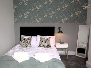 北安普敦的住宿－Modern 3 Bedroom Home in Northampton by HP Accommodation - Free Parking & Super Fast WiFi，一间卧室配有一张带花卉壁纸的床