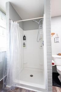 a white bathroom with a shower and a toilet at Suite near downtown Louisville, KY - Suite XI in Louisville