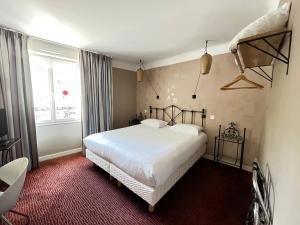 een slaapkamer met een wit bed en een raam bij Grand Hôtel Niort Centre in Niort