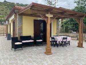 pérgola de madera con mesa y sillas en el patio en Villa Nina en Acciaroli