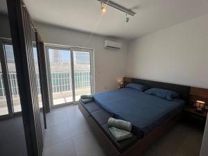 a bedroom with a bed and a large window at Ta Xbiex Sea Front Penthouse in Taʼ Xbiex