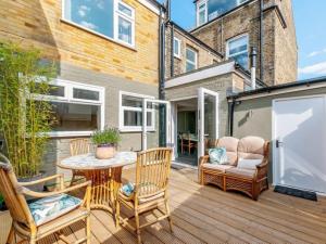 a patio with a table and chairs on a wooden deck at Walpole House sleeps 19-24 in Margate