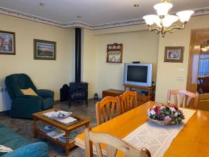 a living room with a dining table and a television at Casa Rural María Josefa in Bronchales