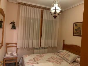 a bedroom with a bed and a chandelier at Casa Rural María Josefa in Bronchales +1 photo